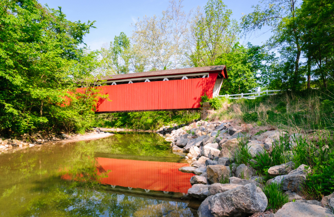 Red covered bridge over a stream